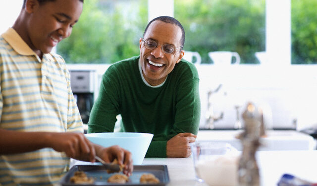 Father Watching Son Bake Cookies --- Image by © Tim Pannell/Corbis